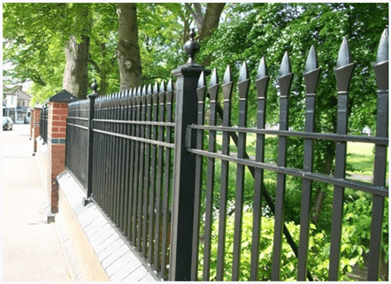 A mid-height fence formed of a low-level brick wall, approximately 6-8 courses high, with taller brick piers to provide support for cast iron, decorative fence panels