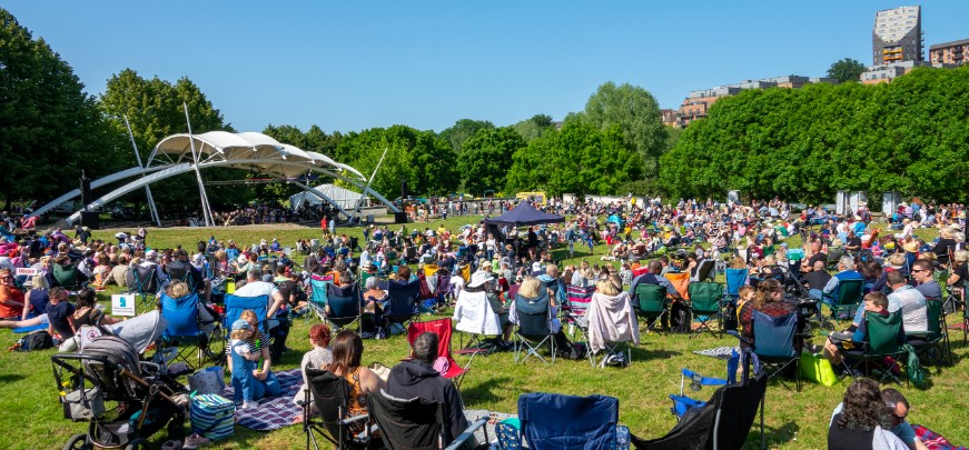 Local residents enjoying a music event in a field.