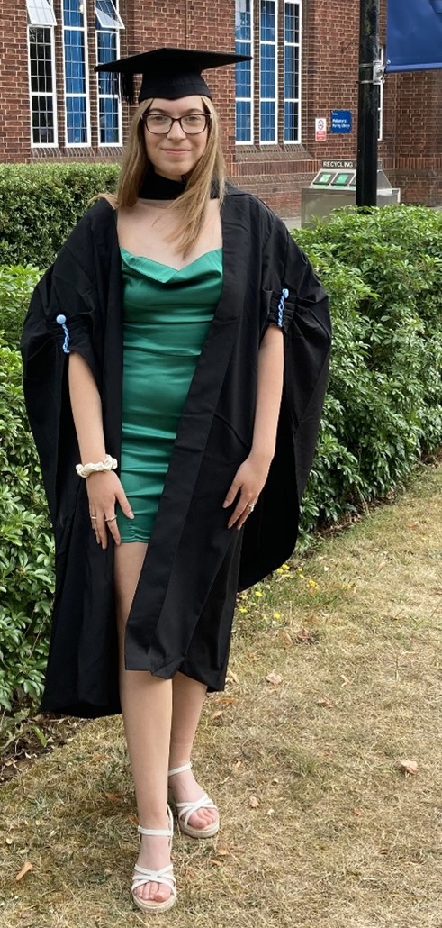 A young lady wearing a graduation gown