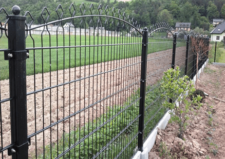 A low-level fence approximately 1.2m high formed of secure posts with a wire mesh panels, with decorative shaped tops to provide some decorative detail