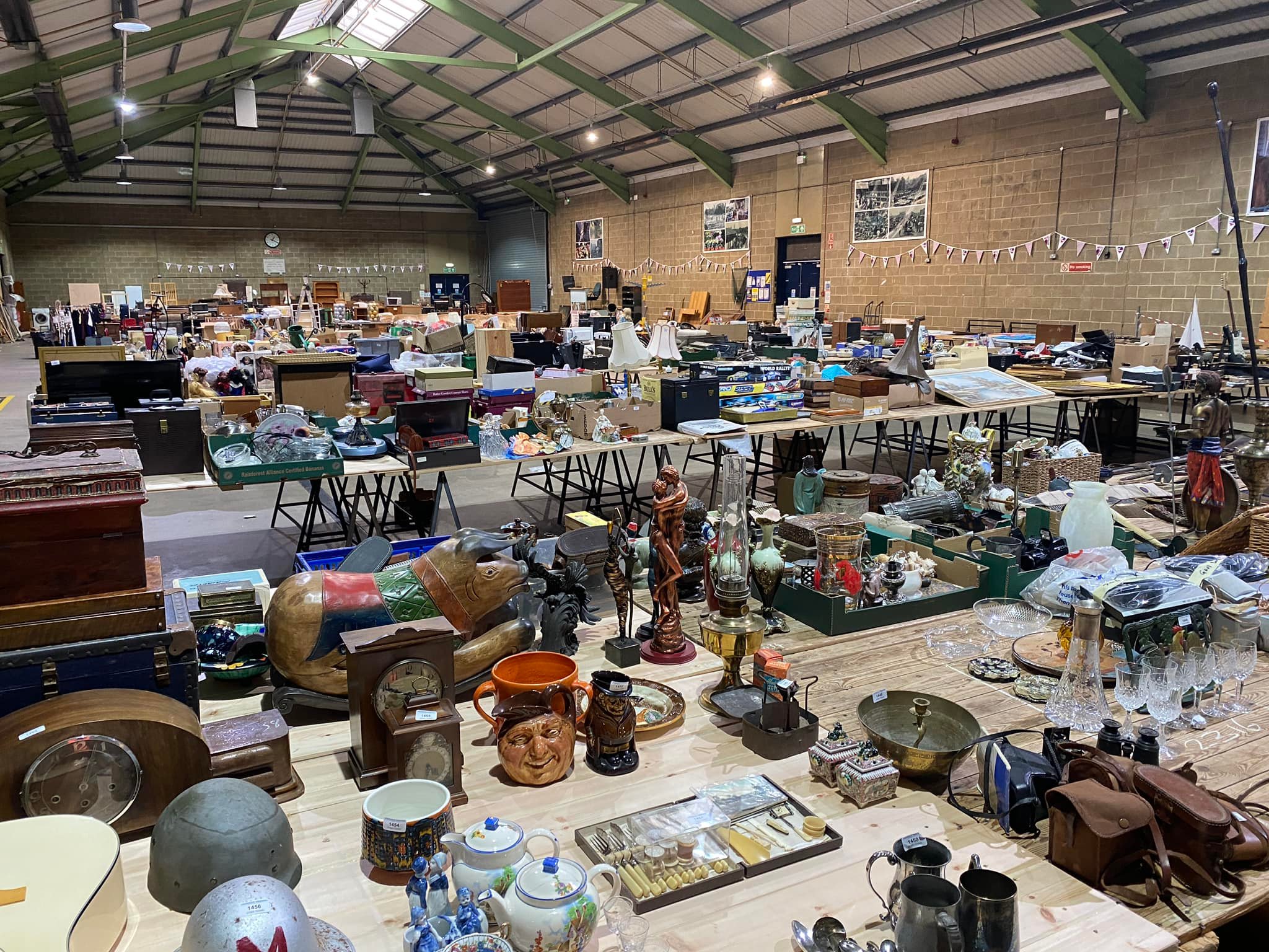 A industrial type hall with a triangular roof filled with stalls of bric-a-brac
